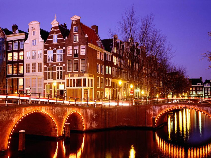 Фото достопримечательностей Амстердама: Дома и подсвеченный мост в районе Грахтенхордэл (Grachtengordel)