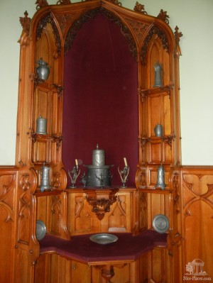 Деревянная этажерка с оловянной посудой в летней столовой замка Леднице (Чехия)