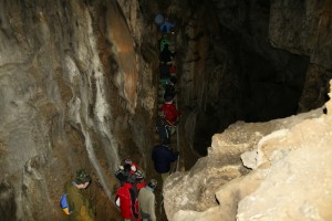 Туристы пробираются по узкому коридору Мамонтовой пещеры (Крым)
